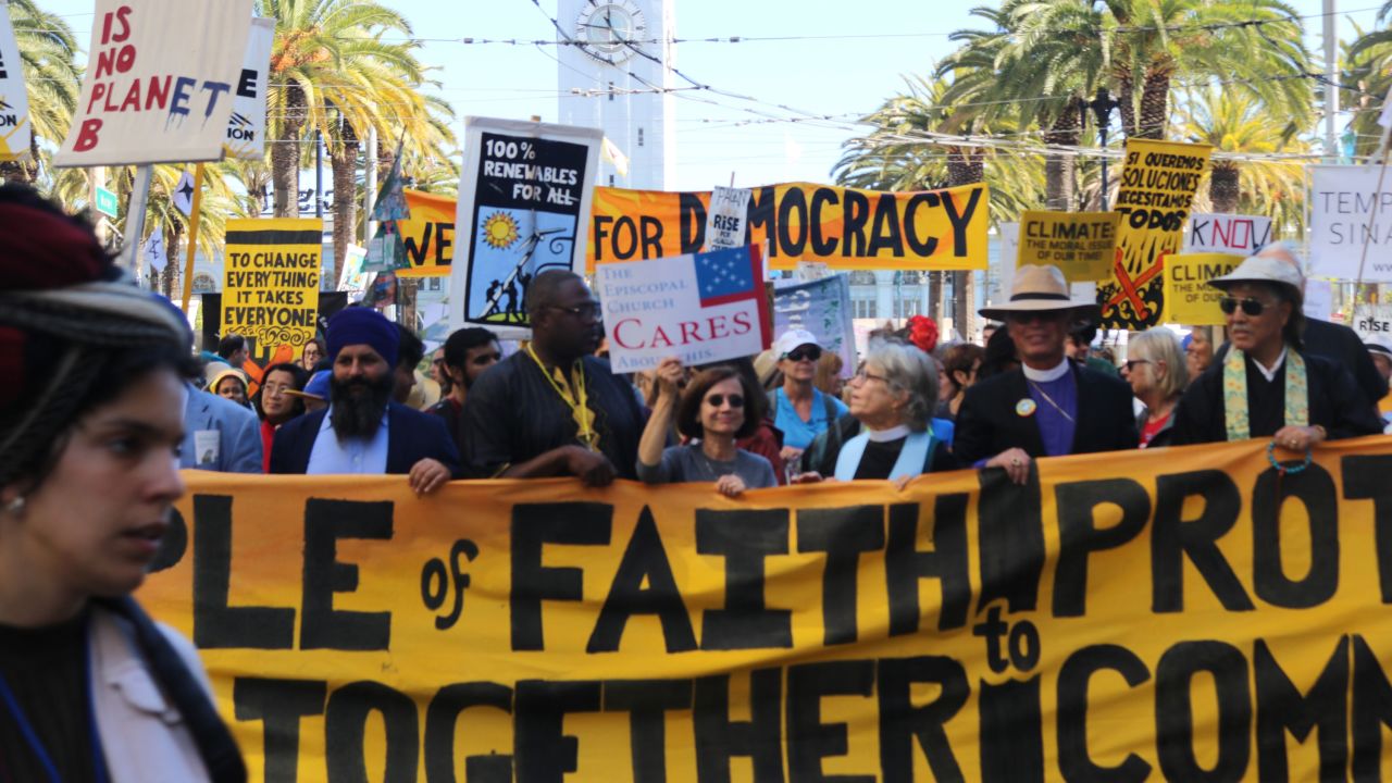 The Rev. Ambrose Carroll (second from the left standing behind the banner) marches during the People's Climate March.