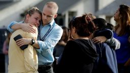 D.J. Hamburger, center in blue, a teacher at Saugus High School, comforts a student after reports of a shooting at the school on Thursday, Nov. 14, 2019, in Santa Clarita, Calif. (AP Photo/Marcio Jose Sanchez)