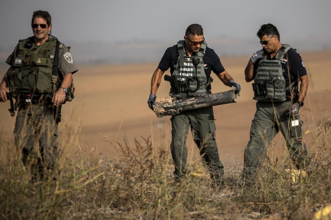 Israeli police sappers remove a rocket fired from the Gaza Strip in farmland near the border on Wednesday.