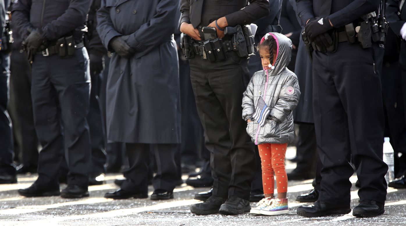 A child stands with police officers as they pay their respects to Jorge Del Rio, a detective from Dayton, Ohio, on Tuesday, November 12. <a href="https://www.cnn.com/2019/11/06/us/dayton-ohio-detective-shot-face/index.html" target="_blank">Del Rio was fatally shot</a> while serving a search warrant earlier this month.