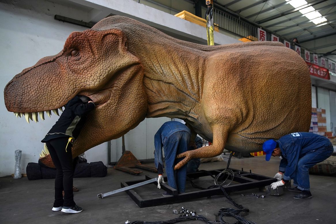 Workers do maintenance on an animatronic dinosaur in Zigong, China, on Wednesday, November 13.