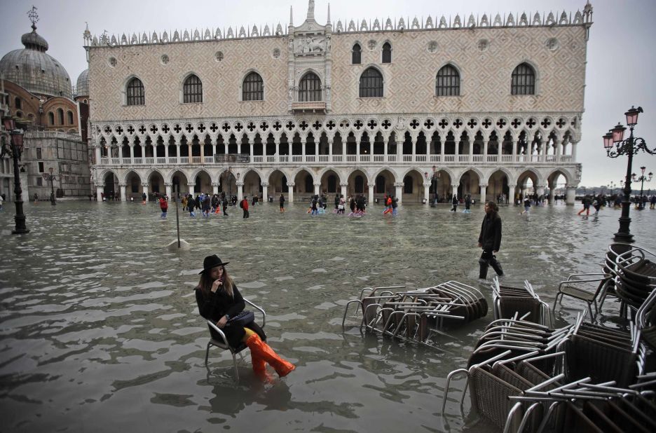 A woman sits in a chair in a flooded St. Mark's Square on November 13.