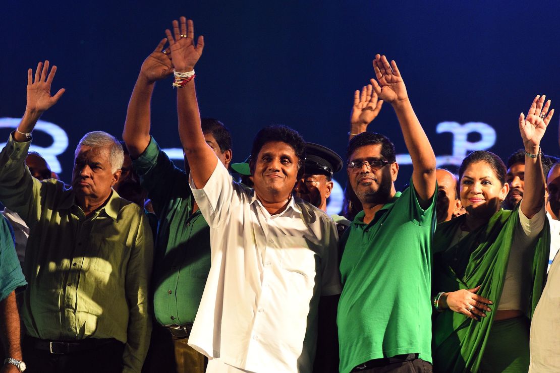 Presidential candidate Sajith Premadasa (center) and Sri Lanka's Prime Minister Ranil Wickremesinghe (left) wave to supporters as they attend a campaign rally in the Sri Lankan capital of Colombo on November 13, 2019.