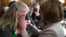 Sandy Phillips, whose daughter Jessi Ghawi was killed in the Aurora, Colo., movie theater shooting, left, kisses the hands of House Speaker Nancy Pelosi of Calif., following a news conference to announce the introduction of bipartisan legislation to expand background checks for sales and transfers of firearms, on Capitol Hill, Tuesday, Jan. 8, 2019 in Washington.