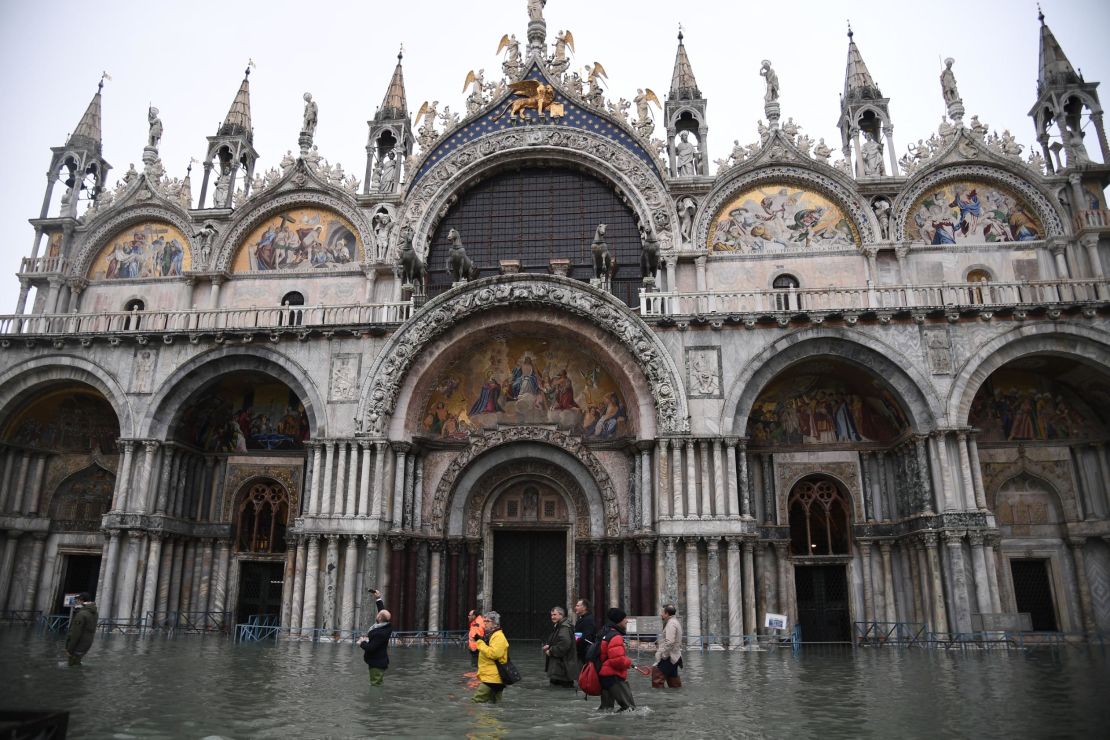 People walk across the flooded St. Mark's square past St. Mark's Basilica on Wednesday, November 13.