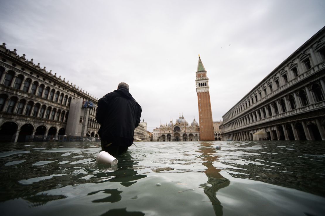 A man walks across the flooded St. Mark's Square on November 15, 2019.