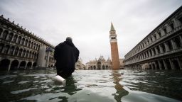 A man walks across the flooded St. Mark's Square, with St. Mark's Basilica (Rear L) and the Bell Tower on November 15, 2019 in Venice, two days after the city suffered its highest tide in 50 years. - Flood-hit Venice was bracing for another exceptional high tide on November 15, as Italy declared a state of emergency for the UNESCO city where perilous deluges have caused millions of euros worth of damage. (Photo by Filippo MONTEFORTE / AFP) (Photo by FILIPPO MONTEFORTE/AFP via Getty Images)