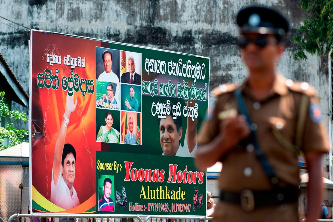 A policeman stands guard at a roadblock near an electoral poster of deputy leader of the ruling United National Party (UNP) and New Democratic Front presidential candidate Sajith Premadasa before a campaign rally in Colombo on November 13, 2019.