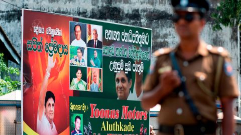A policeman stands guard at a roadblock near an electoral poster of deputy leader of the ruling United National Party (UNP) and New Democratic Front presidential candidate Sajith Premadasa before a campaign rally in Colombo on November 13, 2019.