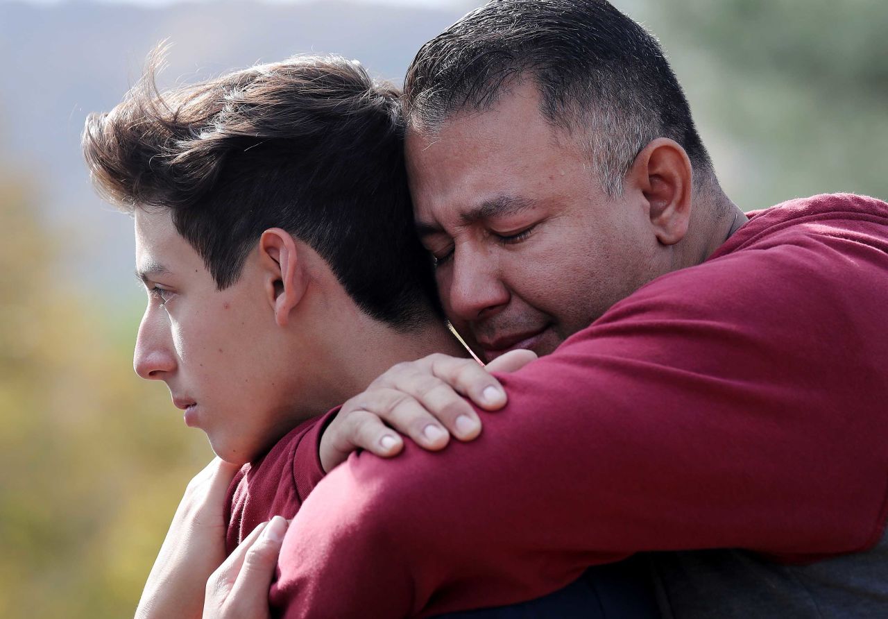 Marco Reynoso, right, hugs his son, 11th-grader Dylan Reynoso, after reuniting at a park near Saugus High School.