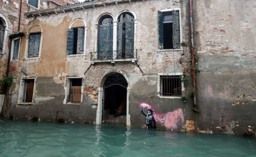 Banksy's migrant child mural is seen <a href="https://edition.cnn.com/style/article/banksy-work-venice-floods-scli-intl/index.html" target="_blank">partially submerged</a> on Friday.