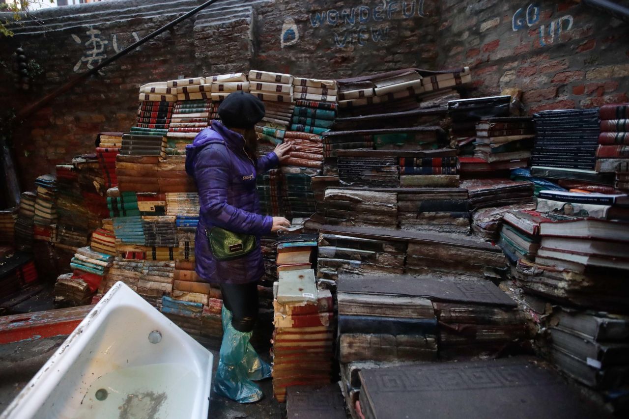 A woman checks the state of books from renowned bookstore "Acqua Alta" (High Water) on Friday after flooding in Venice.