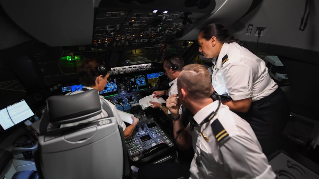 Captain Trennery, left, and her crew talk in the cockpit.