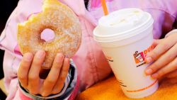 FILE- In this Feb. 14, 2013 file photo, a girl holds a beverage, served in a foam cup, and a donut at a Dunkin' Donuts in New York. The new year means no more plastic foam coffee cups, takeout containers or packing peanuts in most places in the nation's largest city. New York City's long-planned ban took effect on Tuesday, January 1, 2019. (AP Photo/Mark Lennihan, File)