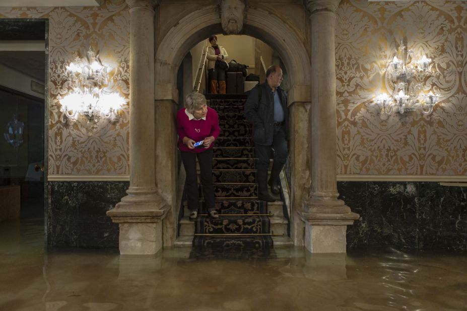 Guests inspect high tidal waters inside a Venice hotel, on Friday, November 15.