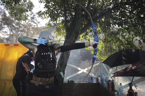 A protester prepares to shoot an arrow during a confrontation with police. 