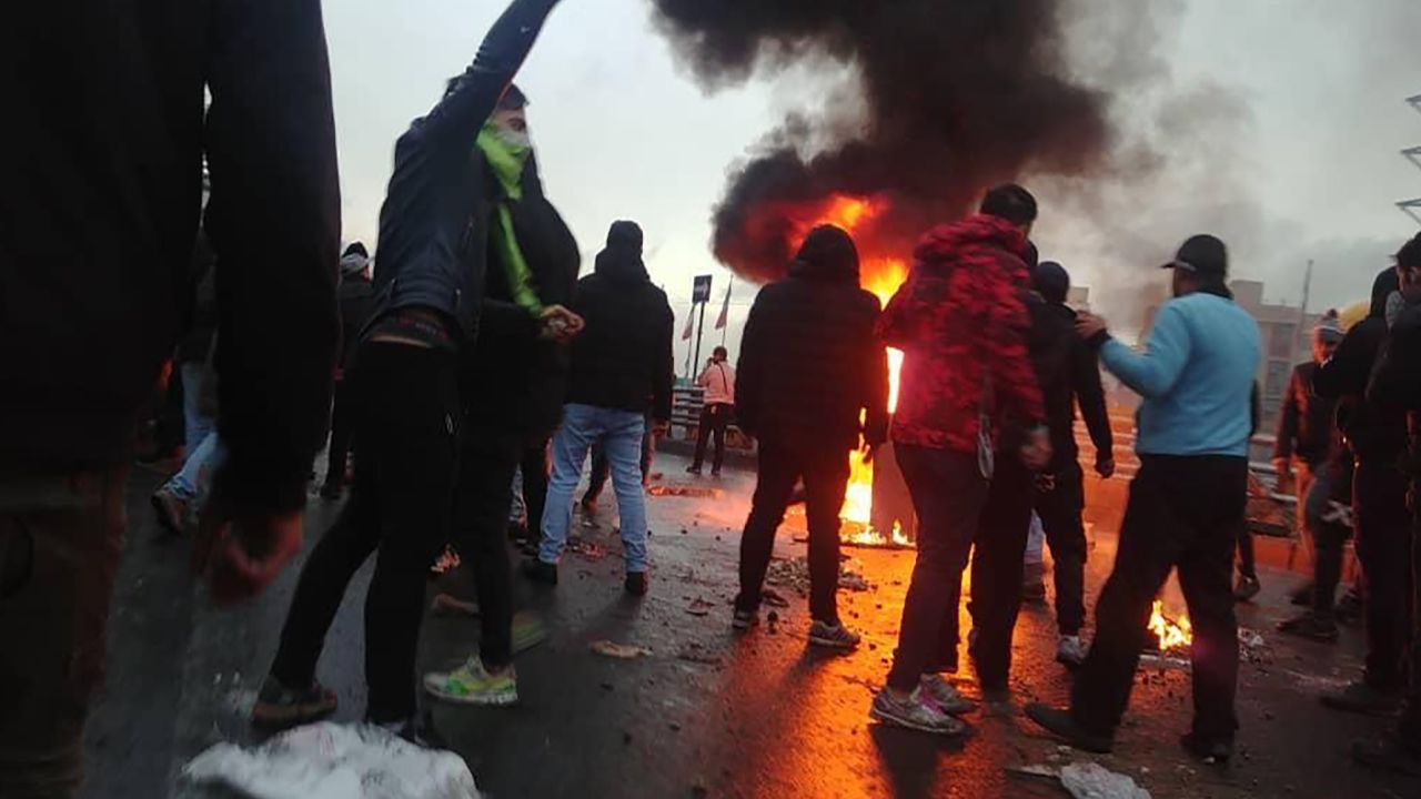 Iranian protesters gather around a fire during a demonstration against an increase in gasoline prices in the capital Tehran on November 16, 2019.