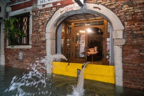 Pumps spout water from a flooded restaurant on November 17.
