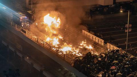 A police armored vehicle catches fire as protesters and police clash on a bridge at the Hong Kong Polytechnic University on Sunday night.