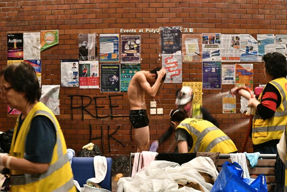 An anti-government protester is showered down by volunteer medical workers after he was soaked by a police water cannons firing pepper spray-infused water at Hong Kong Polytechnic University on November 18.