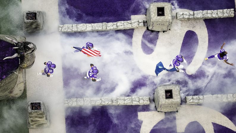 Minnesota Vikings players run onto the field during team introductions prior to their football game against the Denver Broncos in Minneapolis, Minnesota, on Sunday, November 17.