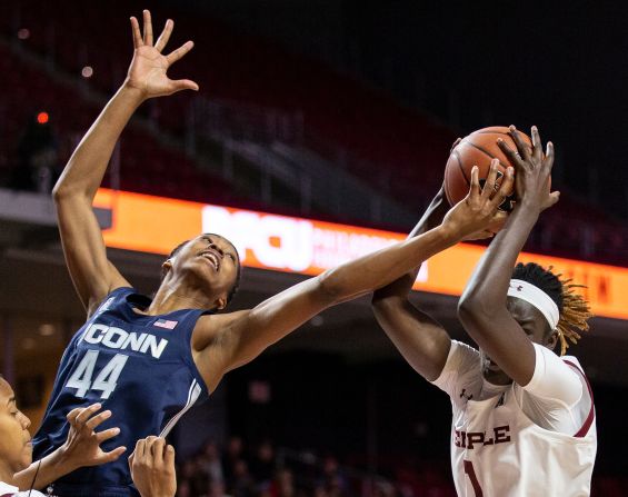 Connecticut guard Aubrey Griffin and Temple forward Lena Niang reach for a rebound during the first half of an NCAA college basketball game on Sunday, November 17 in Philadelphia.