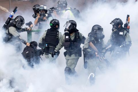 Police in riot gear move through a cloud of smoke as they detain a protester at the Hong Kong Polytechnic University in Hong Kong on November 18. Police have <a href=