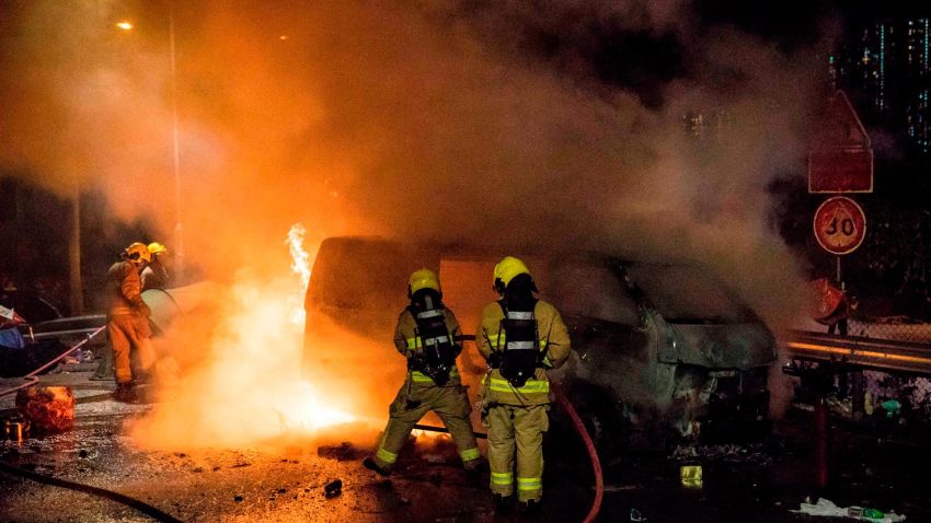 Firemen put out a fire in a van, part of a barricade, after protesters set it alight near the Chinese University of Hong Kong (CUHK) on November 15, 2019. - Protests which began against a now-shelved extradition bill to China have spiralled into wider calls for democracy and police accountability as violence and demonstrations roil the city, challenging Beijing's authority. (Photo by DALE DE LA REY / AFP) (Photo by DALE DE LA REY/AFP via Getty Images)