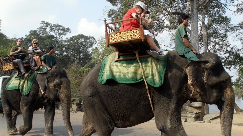 Phnom Penh, CAMBODIA: Foreign tourists ride on elephants visit the Cambodia's famed Angkor Wat temple in Siem Reap province some 314 kilometers north-west of Phnom Penh, 01 March 2007. ASEAN foreign ministers are expected to hold their first talks in Siem Reap, the gateway to Cambodia's famed Angkor Wat complex, on 02 March on an unprecedented charter, seen as crucial for shoring up the bloc's credibility, Cambodian officials. AFP PHOTO/ TANG CHHIN SOTHY (Photo credit should read TANG CHHIN SOTHY/AFP via Getty Images)