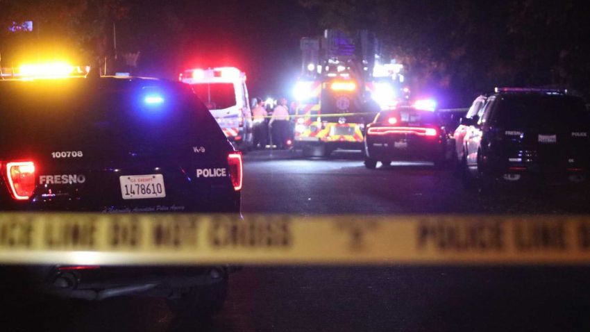 Police and emergency vehicles work at the scene of a shooting at a backyard party, Sunday, Nov. 17, 2019, in southeast Fresno, Calif. Multiple people were shot and at least four of them were killed Sunday at a party in Fresno when suspects sneaked into the backyard and fired into the crowd, police said. (Larry Valenzuela/The Fresno Bee via AP)