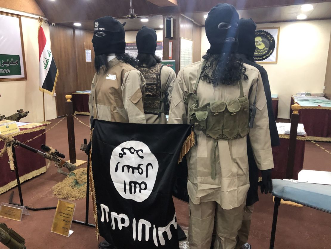 Models of ISIS soldiers hold their flag upside down.