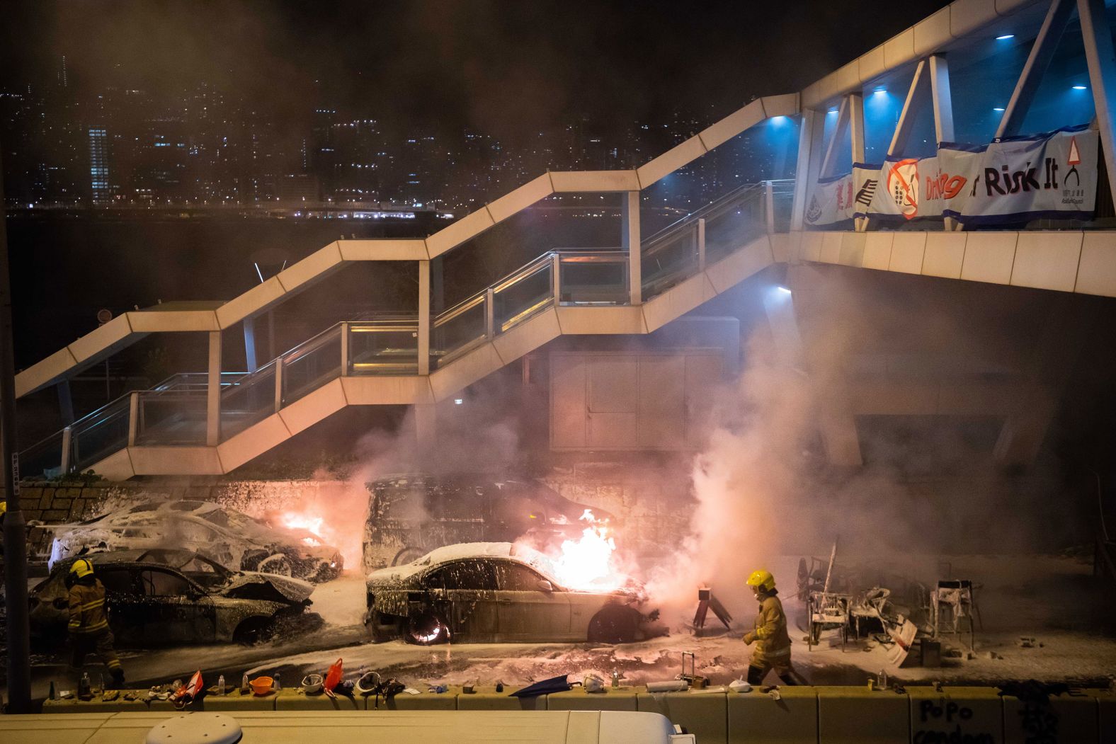 Firefighters put out a burning car set on fire by protesters near Hong Kong Polytechnic University in the Tsim Sha Tsui district on November 18.