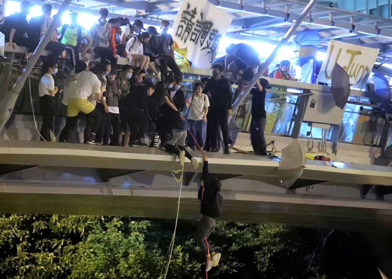 Protesters use a rope to lower themselves from a pedestrian bridge to waiting motorbikes to escape from police at Hong Kong Polytechnic University on November 18.