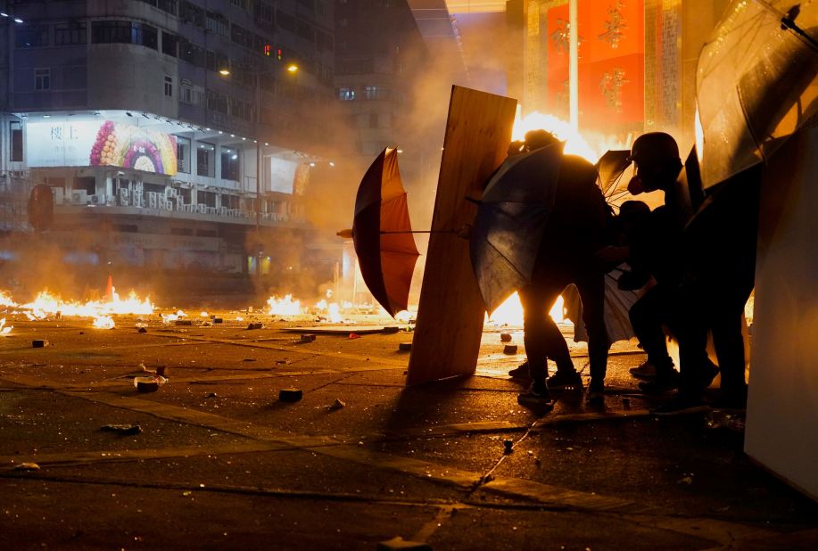 Protesters react as police fire tear gas in the Kowloon area of Hong Kong, Monday, November 18. 