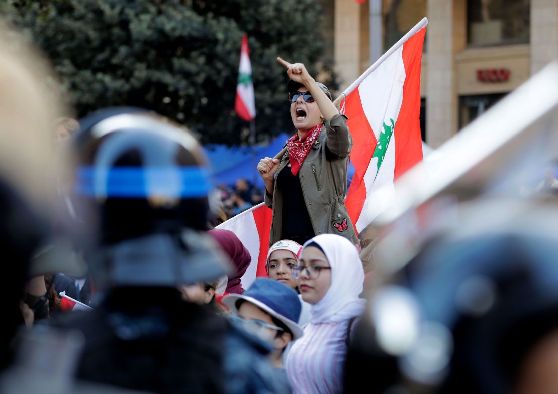 A Lebanese protester holds a national flag as she chants during a demonstration at Riad al-Solh square, Beirut, on Tuesday.