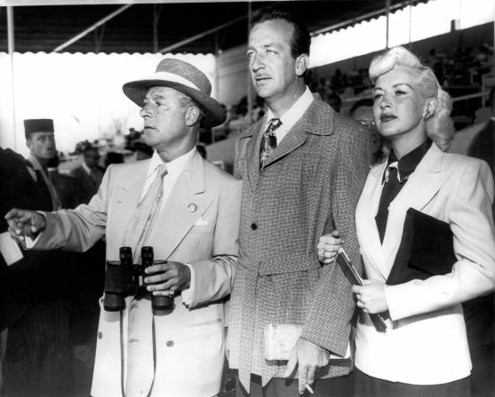 Georgie Jessel, Harry James and Betty Grable watch a race in the early 1950s.