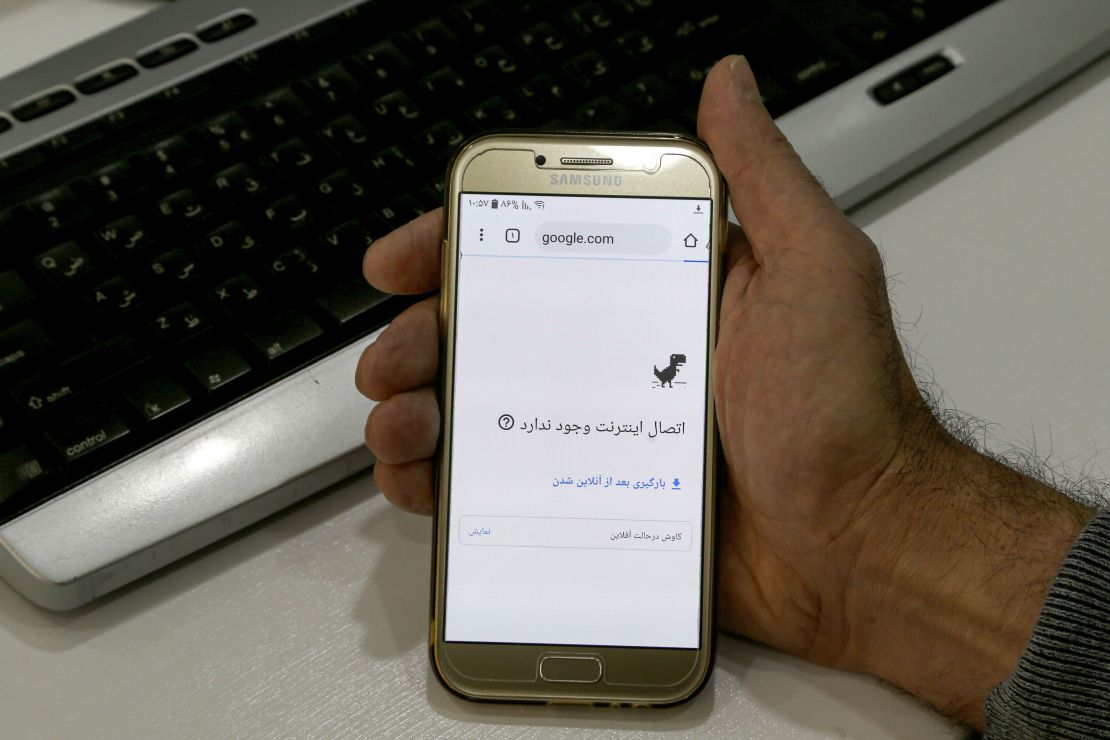 A man holds a smartphone connected to a Wifi network without internet access in Tehran on November 17, 2019.