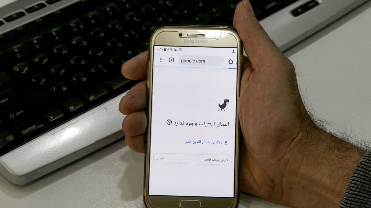 A man holds a smartphone connected to a Wifi network without internet access in Tehran on November 17, 2019.