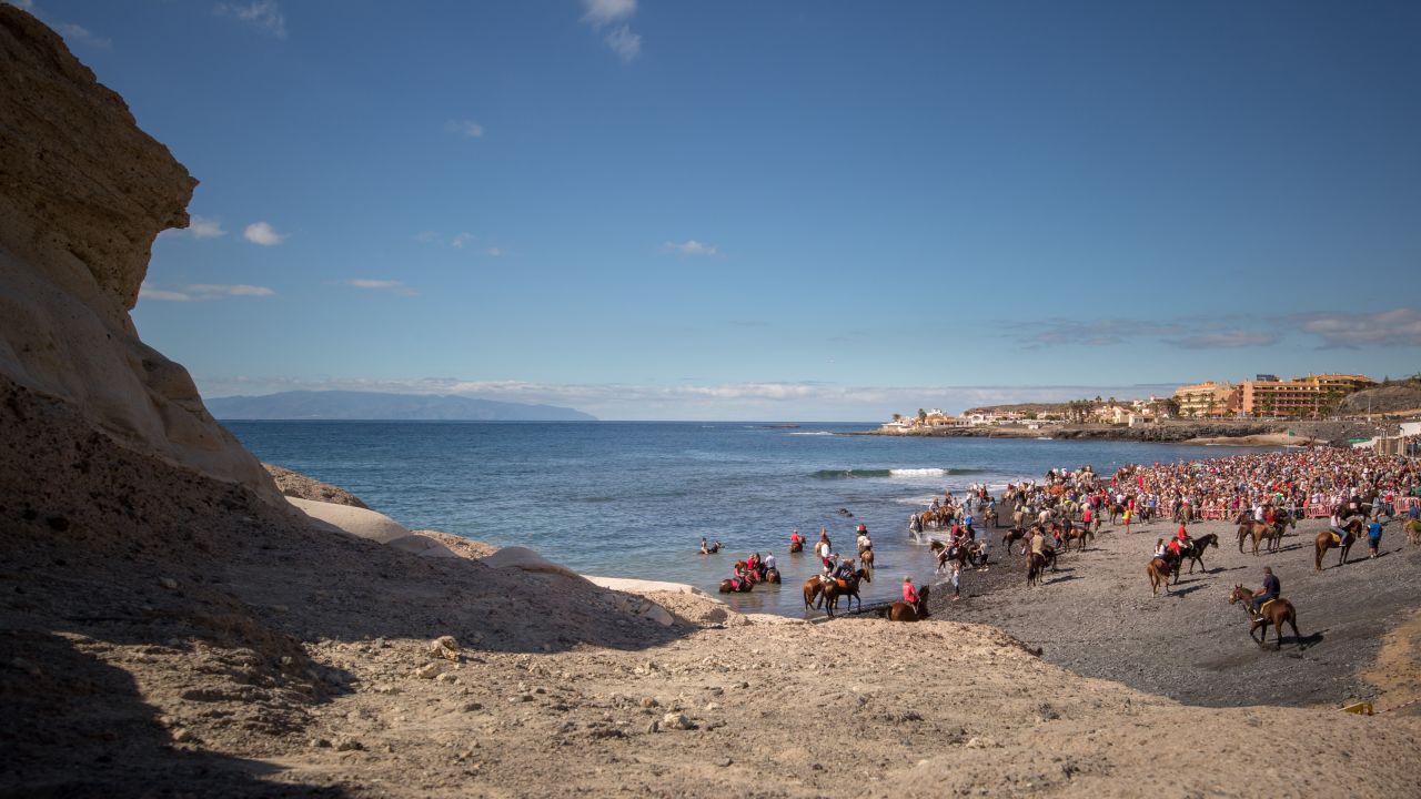 Men ride their horses at the Enramada beach during a celebration on Tenerife.