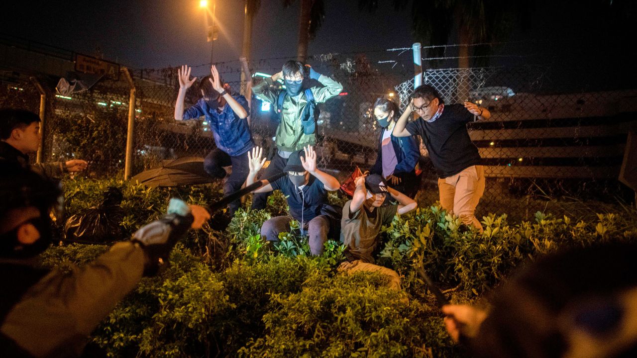 Police detain protesters and students after they tried to flee outside the Hong Kong Polytechnic University campus in the Hung Hom district of Hong Kong on November 19, 2019. - A dwindling number of exhausted pro-democracy protesters barricaded inside the Hong Kong university defied warnings on November 19 to surrender, as a police siege of the campus stretched through a third day and China sent fresh signals that its patience with nearly six months of unrest was running out.