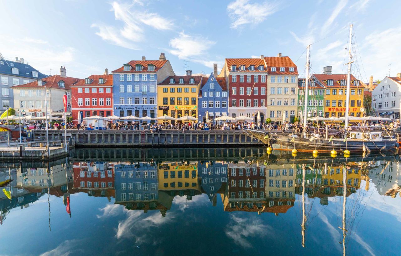 Buildings, architecture, boats and reflections along the Nyhavn in Copenhagen, Denmark.