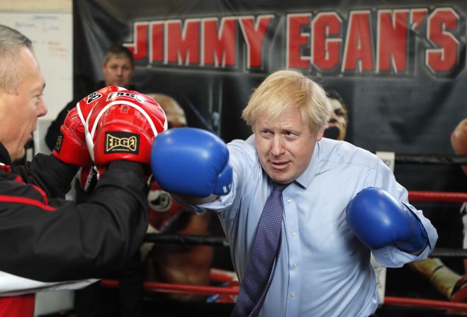 British Prime Minister Boris Johnson works out with trainer Steve Egan during a campaign stop in Manchester, England, on Tuesday, November 19. 
