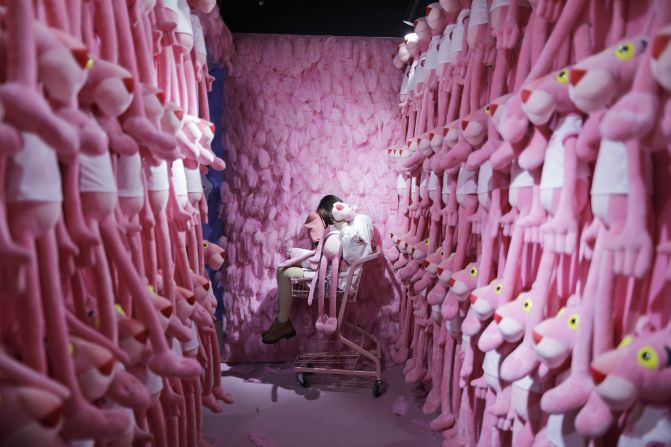 A woman sits in a shopping cart with Pink Panther toys around her at a stress-relief museum in Suzhou, China, on Monday, November 18.