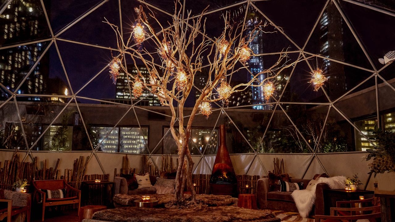 The west terrace of the hotel's rooftop bar, Salon de Ning, has been transformed into a winter chalet, outfitted with faux fur blankets, a fake, Malm-esque fireplace, and soft white lights everywhere.