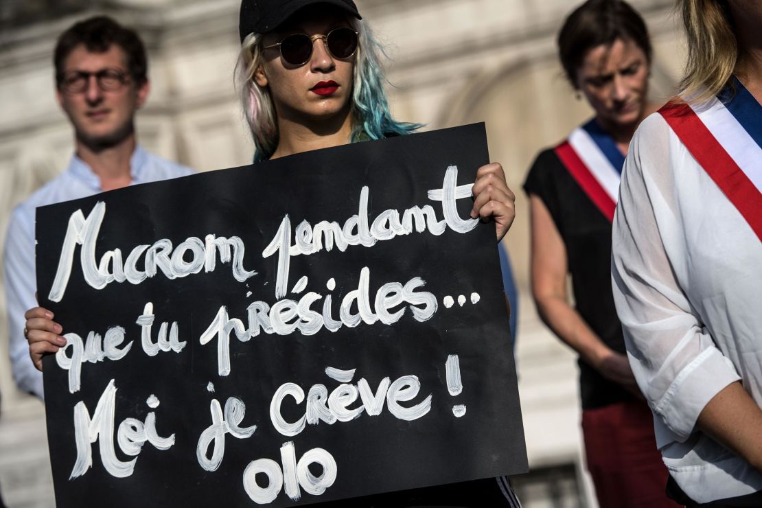 An activist holds a placard reading "Macron while you preside I'm dying" during a demonstration dedicated to the memory of the women killed by their spouse or ex-spouse since the beginning of the year and against the violence against women, in front of the Paris city hall, on August 28.