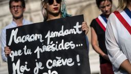 A Femen activist holds a placard reading "Macron while you preside I'm dying" during a protest action dedicated to the memory of the women killed by their spouse or ex-spouse since the beginning of the year and against the violence against women, in front of the Paris city hall, on August 28, 2019. - 97 women have been killed by their spouse or ex-spouse since the beginning of 2019 in France, according to the 'Feminicides by companions or ex' association, and it is estimated that approximately 220,000 women between the ages of 18 and 75 are victims of violence by their former or current partners every year. (Photo by Christophe ARCHAMBAULT / AFP)        (Photo credit should read CHRISTOPHE ARCHAMBAULT/AFP via Getty Images)