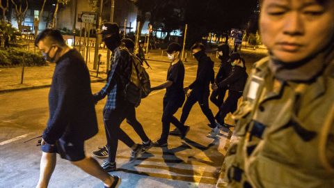 A group of protesters leave the Hong Kong Polytechnic University holding hands before surrendering to police in the Hung Hom district on November 22.