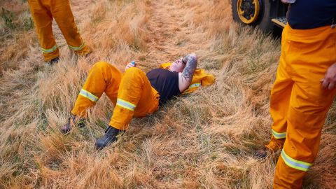 A CFA crew member rests after a day of maintaining controlled back burns in St Albans, Australia, on November 21.