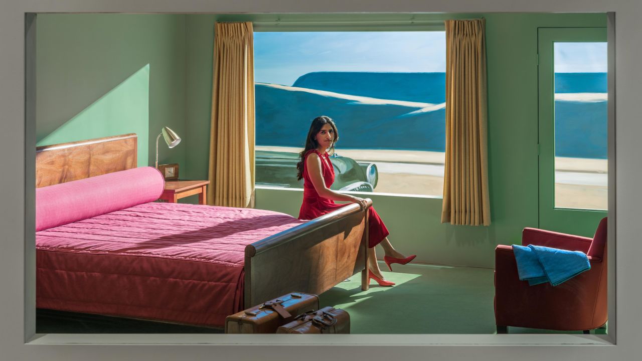 A woman sits in the VMFA Hopper Hotel Room, recreating the classic 1957 painting. 