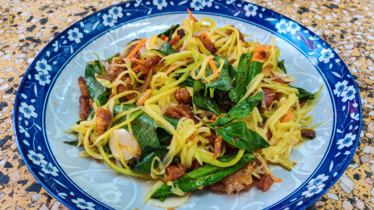 <strong>Nhoam svay kchai (Green mango salad): </strong>Green mango salad is a classic whose flavors of sour fruit, salty smoked fish and sweet palm sugar form a beautifully harmonious whole.